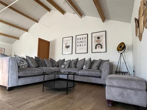a living room with a couch and a table at 3 Bed Barn in Cambridge next to Anglesey Abbey in Cambridge