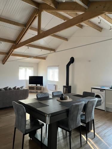 a dining room with a table and chairs in a living room at 3 Bed Barn in Cambridge next to Anglesey Abbey in Cambridge