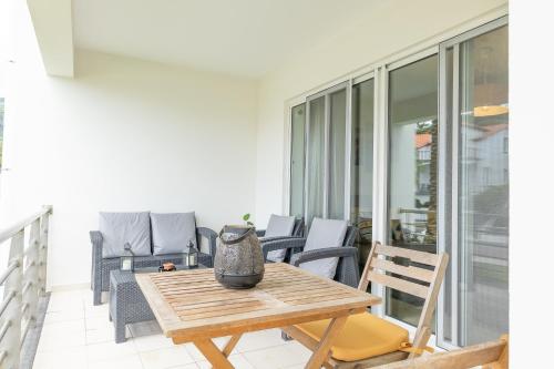 a wooden table and chairs on a balcony at Marina Mar Vila Franca do Campo in Vila Franca do Campo