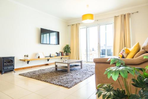 a living room with a couch and a table at Marina Mar Vila Franca do Campo in Vila Franca do Campo