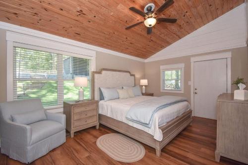 1 dormitorio con 1 cama, ventilador de techo y silla en Blue Haven, en Dadeville