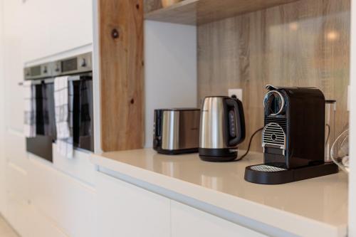 a kitchen with two coffins and a coffee maker on a counter at Hill Rock villas - Blue Silver in Petit-Bourg