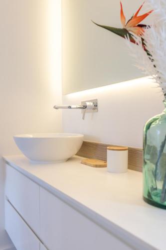 a white counter with a bowl and a mirror at Hill Rock villas - Blue Silver in Petit-Bourg