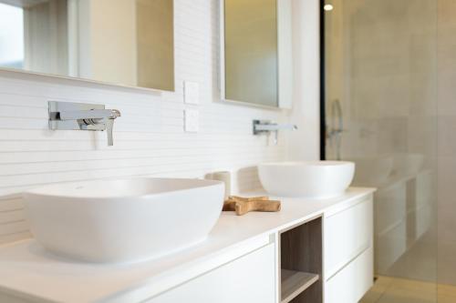 a white bathroom with two sinks and a mirror at Hill Rock villas - Blue Silver in Petit-Bourg