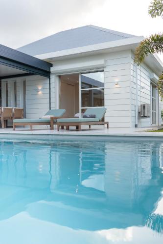a house with a swimming pool in front of a house at Hill Rock villas - Blue Silver in Petit-Bourg