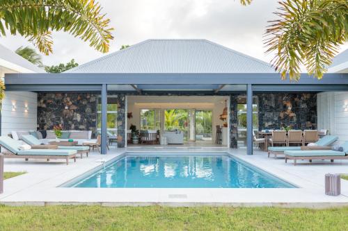 an outdoor patio with a swimming pool and a house at Hill Rock villas - Blue Silver in Petit-Bourg