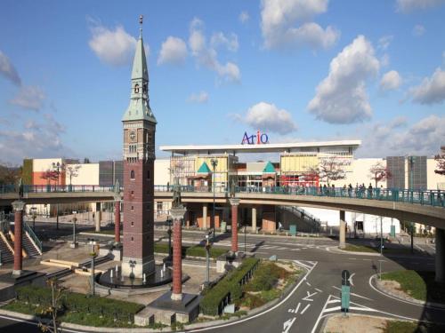 a clock tower in a city with a bridge at APA Hotel Kurashiki Ekimae in Kurashiki