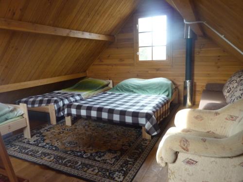 SierakowiceにあるDomek Nad Jezioremのベッド2台とキャビン内のソファが備わる客室です。