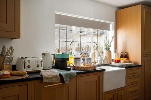 a kitchen with a counter top with a window at Broadway Scandi Chic Authentic Cottage in Broadway