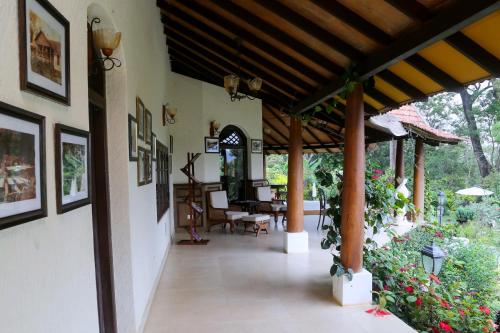 a porch of a house with pictures on the wall at Old Kent Estates & Spa, Coorg in Suntikoppa