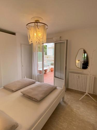 une chambre avec un grand lit et un lustre dans l'établissement Sanary- La vie est belle- Centre Ville 2 minutes à pied- Plage 5 minutes, à Sanary-sur-Mer