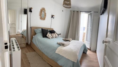 une chambre avec un lit avec des draps bleus et un miroir dans l'établissement Le petit prince, à Boulogne-Billancourt