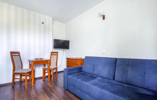 a living room with a blue couch and a table at Gorgeous Apartment In Jastarnia in Jastarnia