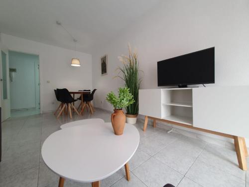 sala de estar con mesa blanca y TV en Casa Victor, en San Pedro del Pinatar