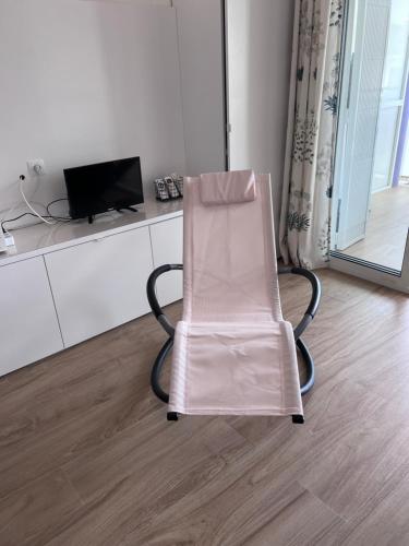 a pink chair in a room with a television at Quiet Salou Beach Front in Salou