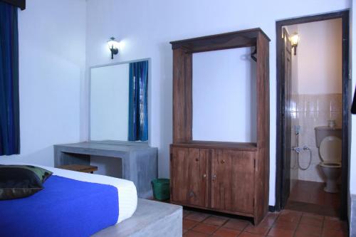 ein Schlafzimmer mit einem Bett und ein Badezimmer mit einem WC in der Unterkunft Dambulu Oya Family Park in Dambulla