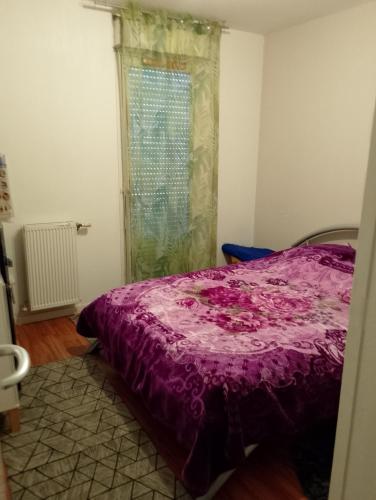a bedroom with a purple bed and a window at Genicar in Lormont