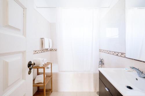 a white bathroom with a sink and a mirror at Monte Sao Pedro - Villa in Luz
