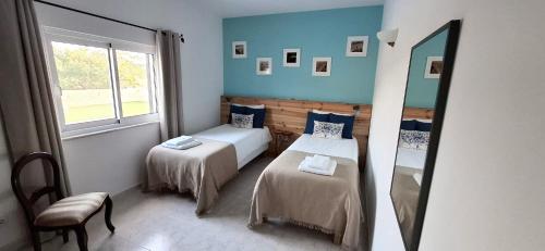 a room with two beds and a mirror in it at Quinta Ribeirinha - Lagos in Lagos