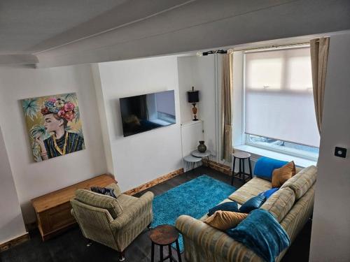 a living room with a couch and a tv at Jubilee Jem in Aberaman