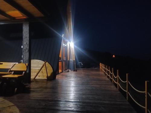 a wooden boardwalk with a light at night at Dream view of Apuseni in Rîmeţi