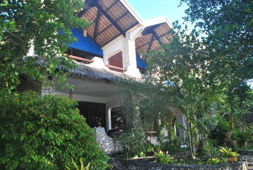 a house with a roof on the side of it at The Blue Orchid Resort in Moalboal