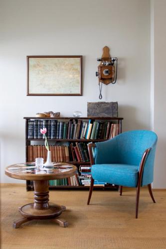 a living room with a blue chair and a table at Gistihúsið - Lake Hotel Egilsstadir in Egilsstadir