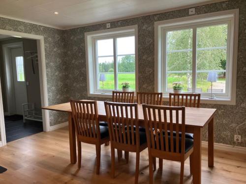 a dining room with a wooden table and chairs at Newly renovated cozy house Urshult-Åsnen-south Småland in Urshult