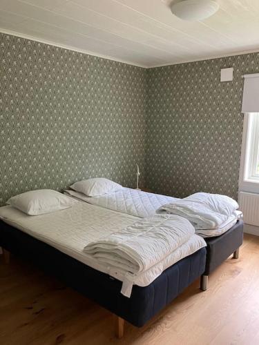 two twin beds in a bedroom with a wall at Newly renovated cozy house Urshult-Åsnen-south Småland in Urshult