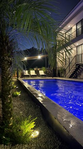 a swimming pool with a palm tree in a building at Villa Maravilla Estates, Tamarindo Beach, Prime Location, Family & Friends in Tamarindo