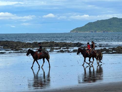 a group of people riding horses on the beach at Villa Maravilla Estates, Tamarindo Beach, Prime Location, Family & Friends in Tamarindo