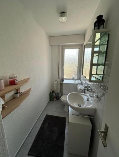 a small bathroom with a sink and a window at Rooftop ink Parking in Lucerne