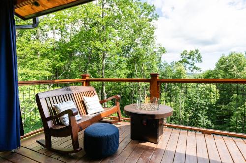 a wooden deck with a bench and a table at Meraki Escape in Brevard