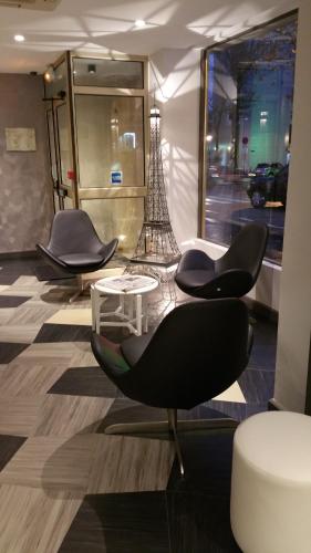 a group of chairs and a table in a room at Eiffel Kennedy in Paris