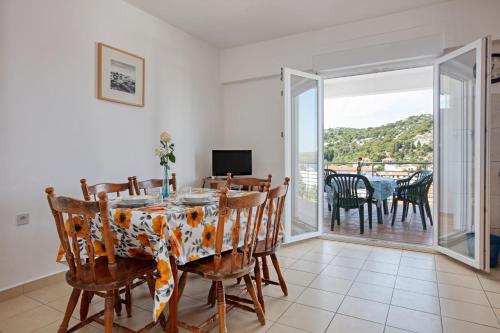 a dining room with a table and chairs and a balcony at Apartment Tisno 4295a in Tisno