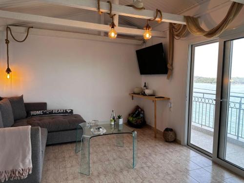 a living room with a couch and a glass table at ARTE MARE d'Irene in Spárton
