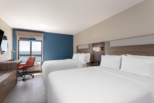 a hotel room with two beds and a desk at Holiday Inn Express Hotel & Suites Tampa-Rocky Point Island by IHG in Tampa