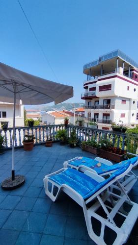 a lounge chair and an umbrella next to a building at Tanja Terrace Appartments Dobre Vode in Dobra Voda
