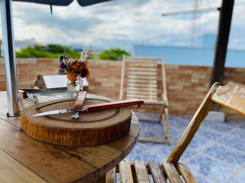 a wooden table with a knife on top of it at Apartamentos exclusivos e equipado com varanda ou terraço com Pôr do sol, cozinha privativa, Wi-Fi 600MBs, a 700m da praia de Itapirubá e 1km da BR-101 in Imbituba