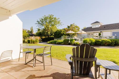 a patio with a table and chairs and a yard at Balcomo, a Ramada by Wyndham in Penticton