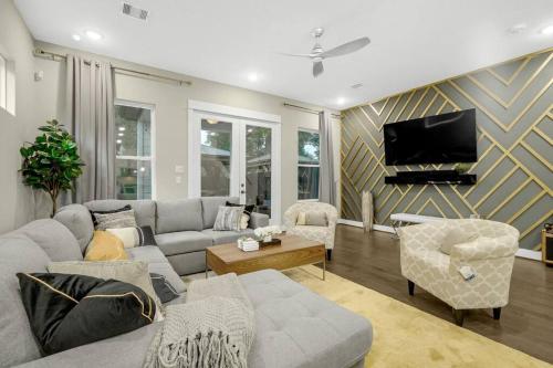 a living room with a couch and a tv at Gray Lux Hse 3BR 3 and half Ba MedCenter DownTWN HotTub in Houston