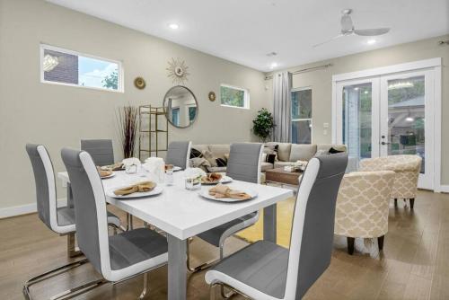a dining room and living room with a table and chairs at Gray Lux Hse 3BR 3 and half Ba MedCenter DownTWN HotTub in Houston