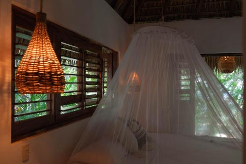 a bedroom with a bed with a mosquito net at Casa Chula Hotel Boutique Frente al Mar in Tierra Blanca