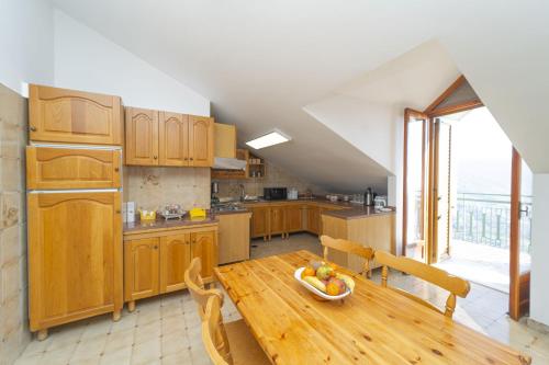 a kitchen with a table with a bowl of fruit on it at Villa Incoronata in Agerola