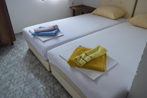 two beds with towels and a purse on them at Tanja Terrace Appartments Dobre Vode in Dobra Voda