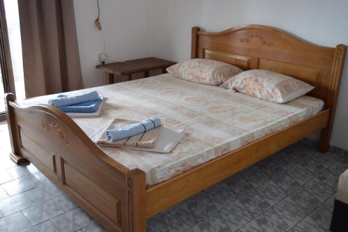 a wooden bed with two pillows and a laptop on it at Tanja Terrace Appartments Dobre Vode in Dobra Voda