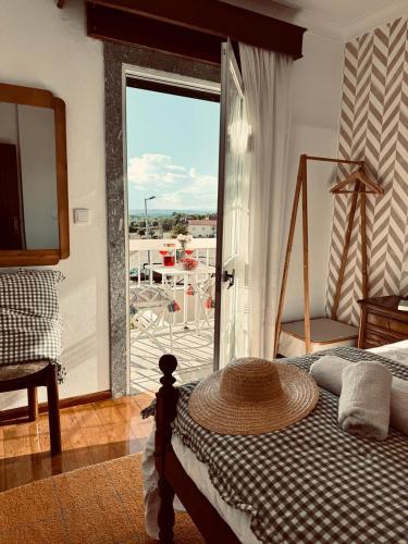 a bedroom with a bed with a view of a balcony at A casa do Boubelo in Vimioso