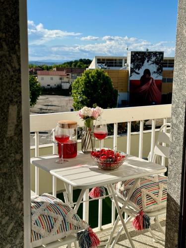 a table with two glasses of wine on a balcony at A casa do Boubelo in Vimioso