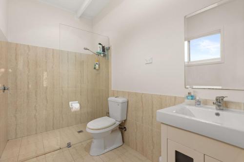 a bathroom with a toilet and a sink at Waterfront Retreat by Book Jervis Bay Getaway Kayaks, Bikes, Fast Wi-Fi and more in Sanctuary Point