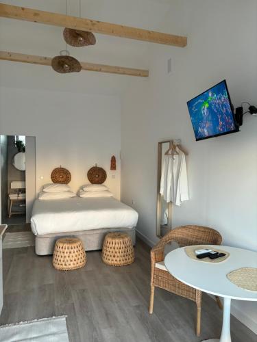 a bedroom with a bed and a table and chairs at Casa do Rio in Nazaré